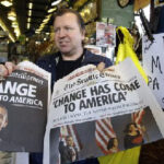 Newspaper vendor Chad Smith displays copies of the Seattle Post-Intelligencer, left, and The Seattle Times, featuring the election of Barack Obama as president, that he had set aside for himself before the editions sold out at the Read All About It newsstand in Seattle's Pike Place Market Wednesday. (Elaine Thompson / Associated Press )